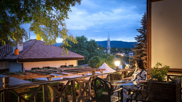 A terrace with a table and chairs, overlooking a town with a prominent tower. - KOLAĞASI KONAK (Safranbolu)