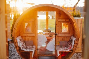A wooden cabin with two benches and a glass door.