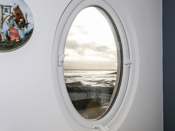 Una ventana con vista a una playa y una ilustración histórica.