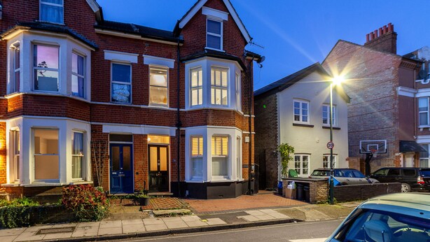A two-story residential building with bay windows, a front door, and a visible street lamp. - The Richmond Apartments (Richmond)