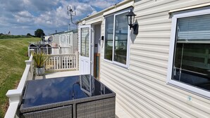 A row of mobile homes with a covered patio area and a fenced deck. - Driftwood Cabin Dog Friendly - Anderby Creek (Skegness)