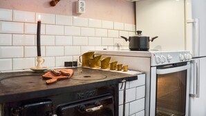 Een keuken met een fornuis, oven en diverse keukengerei.