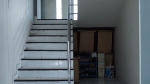 A staircase leading to a storage area with shelves and boxes.