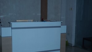 A reception desk with a wooden finish and a grey panel.