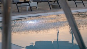 A swimming pool with lounge chairs and umbrellas. - Villa Nontas Ntina with Private Pool (Rethymno)