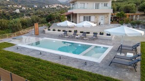 Piscine extérieure, parasols de plage, chaises longues