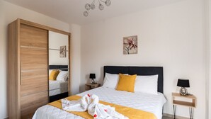 A hotel room with a bed, a wardrobe, a nightstand, and a ceiling light fixture. - Villa Nontas Ntina with Private Pool (Rethymno)