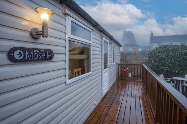 Une terrasse en bois sur laquelle est affiché un panneau indiquant « SWIFT Moselle ».