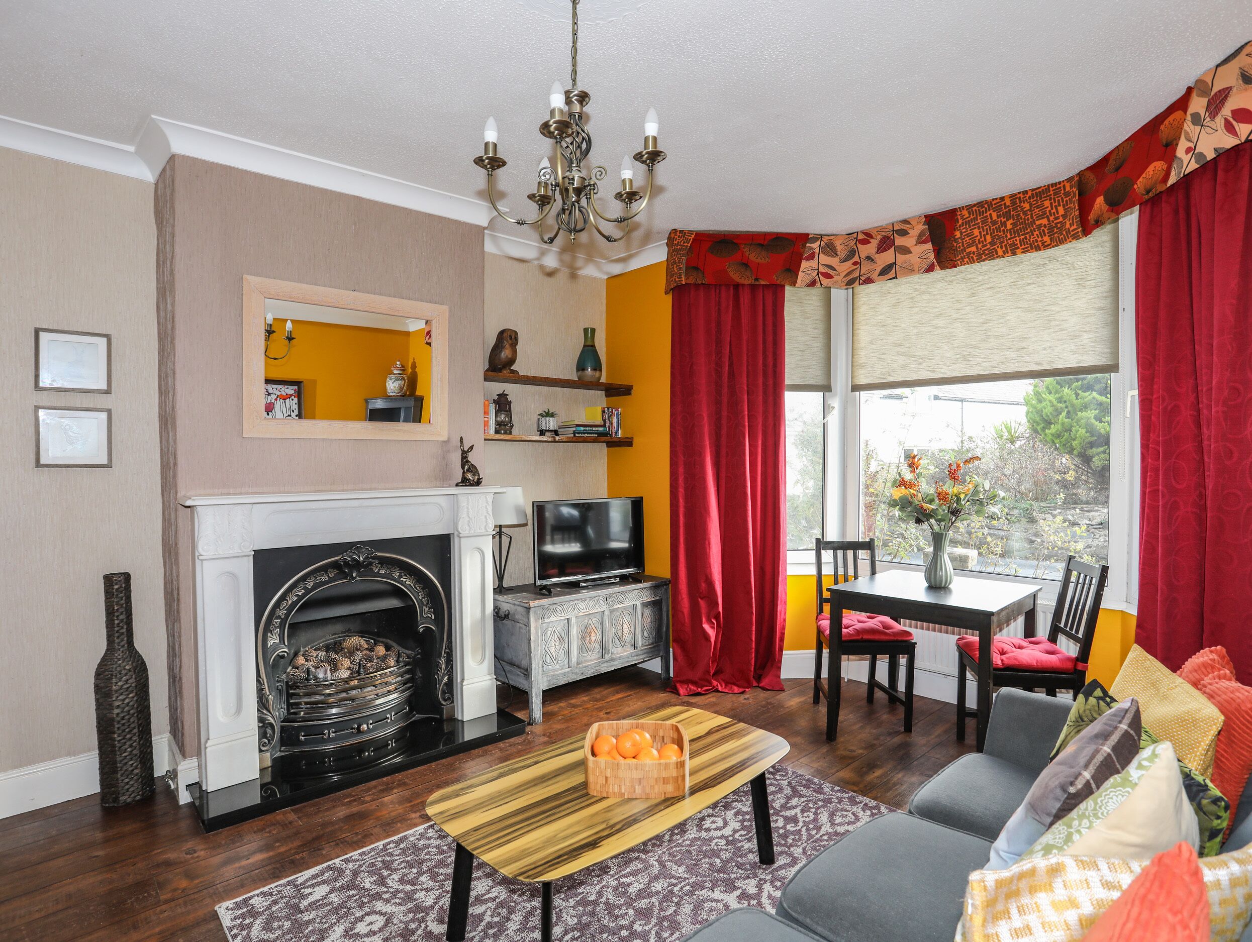 A living room with a fireplace, television, and a dining area with a table and chairs.