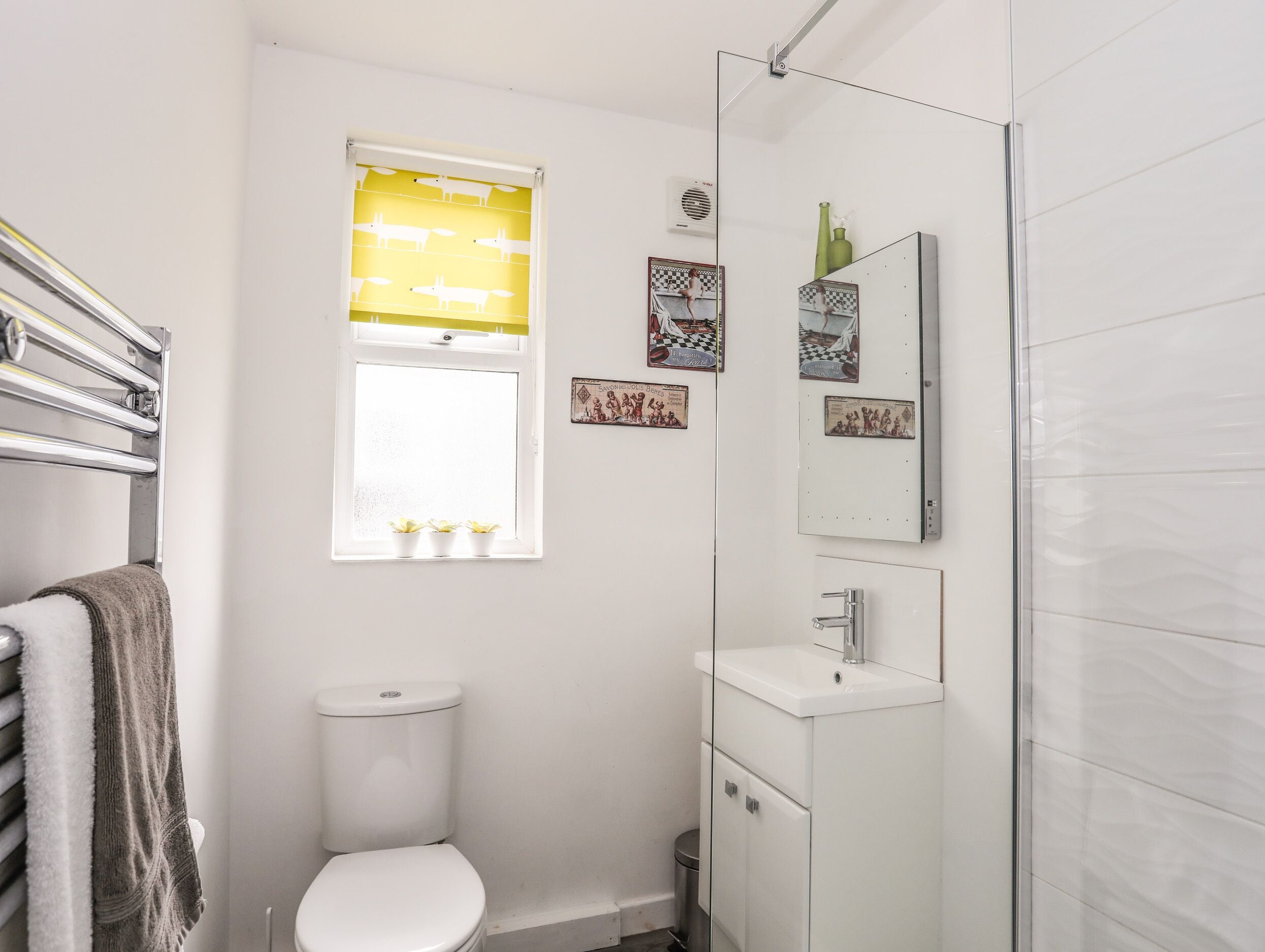 A small, modern bathroom with a toilet, a sink, and a shower.