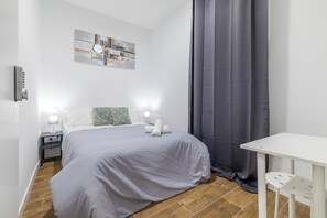 A bedroom with a bed, bedside tables, a wall clock, and a window with a curtain. - AYZ Luis Cabrera-Auto check-in property (Madrid)