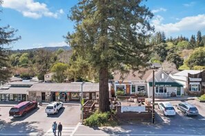 A parking lot with several cars, a large tree, and buildings including a restaurant named 'WYLDER SPACE'.