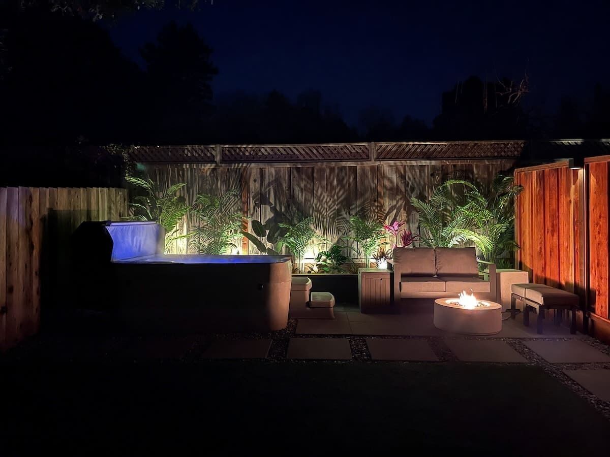 A patio area with a barbecue grill, seating, and potted plants.