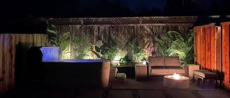 A patio area with a barbecue grill, seating, and potted plants.
