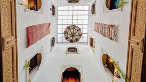 A room with a central skylight, decorative ceiling, and patterned walls. - Riad Tafoukt Palace (Fes)