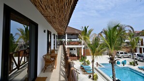 Un resort con piscina, mobiliario exterior y una zona cubierta con vistas a la piscina.