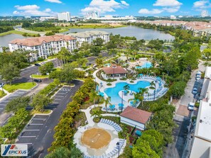 Ein Resort mit mehreren Schwimmbecken, einer zentralen Laube und einem großen See.