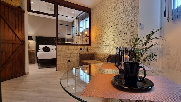A modern interior with a glass table, a black mug, and a stone wall. - Loft Vintage (Santander)