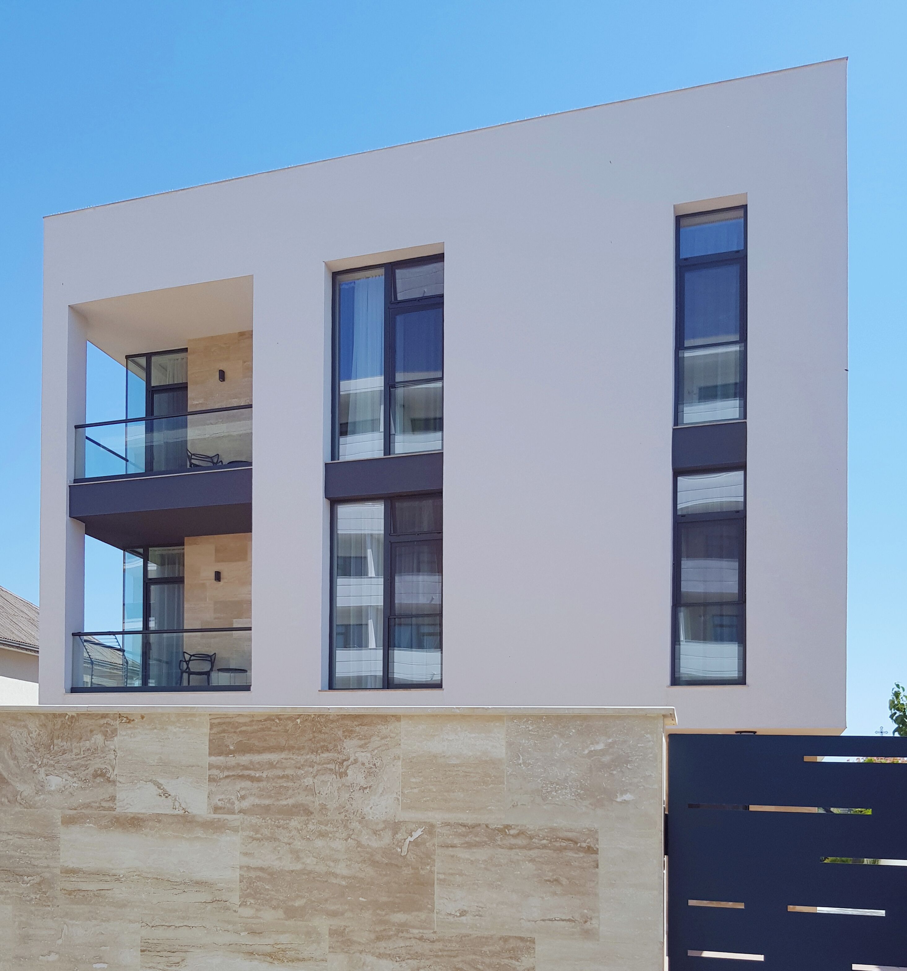 A modern two-story building with a balcony on the upper floor.