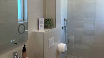 A modern bathroom with a sink, toilet, and shower.