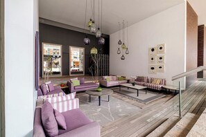 A modern living room with a sofa set, coffee table, and hanging pendant lights.