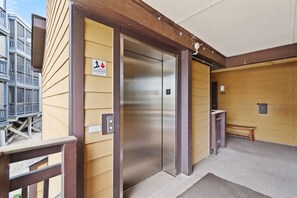 An elevator in a building with a wooden exterior and a metal door. - Condo w/ Pool | Shared Deck & 3BR (Garden City Beach)