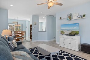 Relax in this stylish living room with a flat-screen TV, dining area, and comfortable seating.
