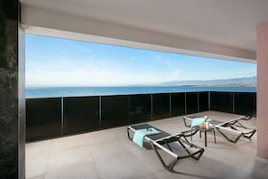 A balcony with a view of the sea and mountains, furnished with lounge chairs and a table. - Apartments Malibu Imperial (Vir)