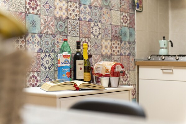 En köksbänk med en bok, flaskor och matvaror.