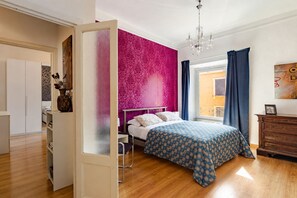 Un dormitorio con cama, cómoda, ventana con cortinas y vistas al exterior.