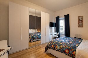 A bedroom with a bed, a desk, a chair, a wardrobe, and a window with curtains. - Rome La Sapienza Apartment (Rome)