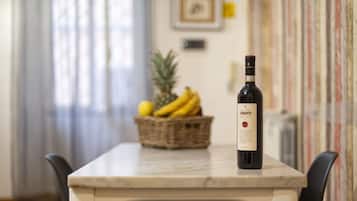 Una bottiglia di vino Chianti su un tavolo in marmo con un cesto di vimini contenente banane e un'ananas sullo sfondo.