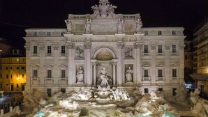 Ein prachtvolles Gebäude mit einem großen Brunnen davor, mit Statuen und Inschriften.