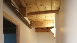Una escalera estrecha con barandillas de madera que lleva a un dormitorio con literas.