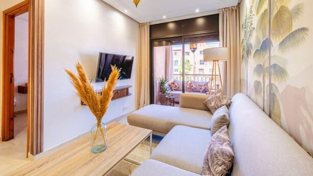 Ein modernes Wohnzimmer mit einer Couch, einem Flachbildfernseher und einer dekorativen Vase.
