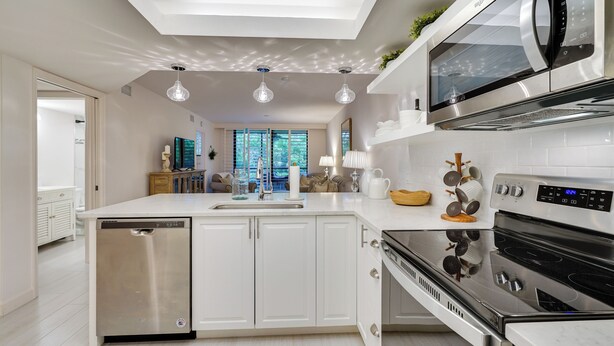 A modern kitchen with a dishwasher, oven, microwave, and a large island with a sink. - Bonita Springs Condo w/ Community Pool! (Bonita Springs)