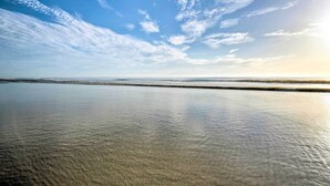 Una playa con agua tranquila y cielo despejado.