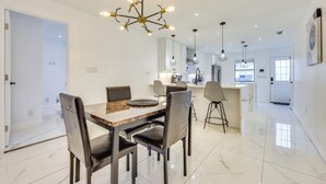A modern kitchen with white cabinets, a central island, and pendant lighting.