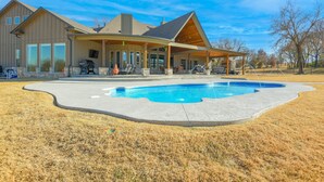 A house with a large swimming pool, a covered patio, and a well-maintained lawn. - Spacious Owasso Vacation Rental w/ Private Pool! (Owasso)