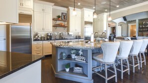 A modern kitchen with white cabinets, stainless steel appliances, and a granite countertop. - Spacious Owasso Vacation Rental w/ Private Pool! (Owasso)