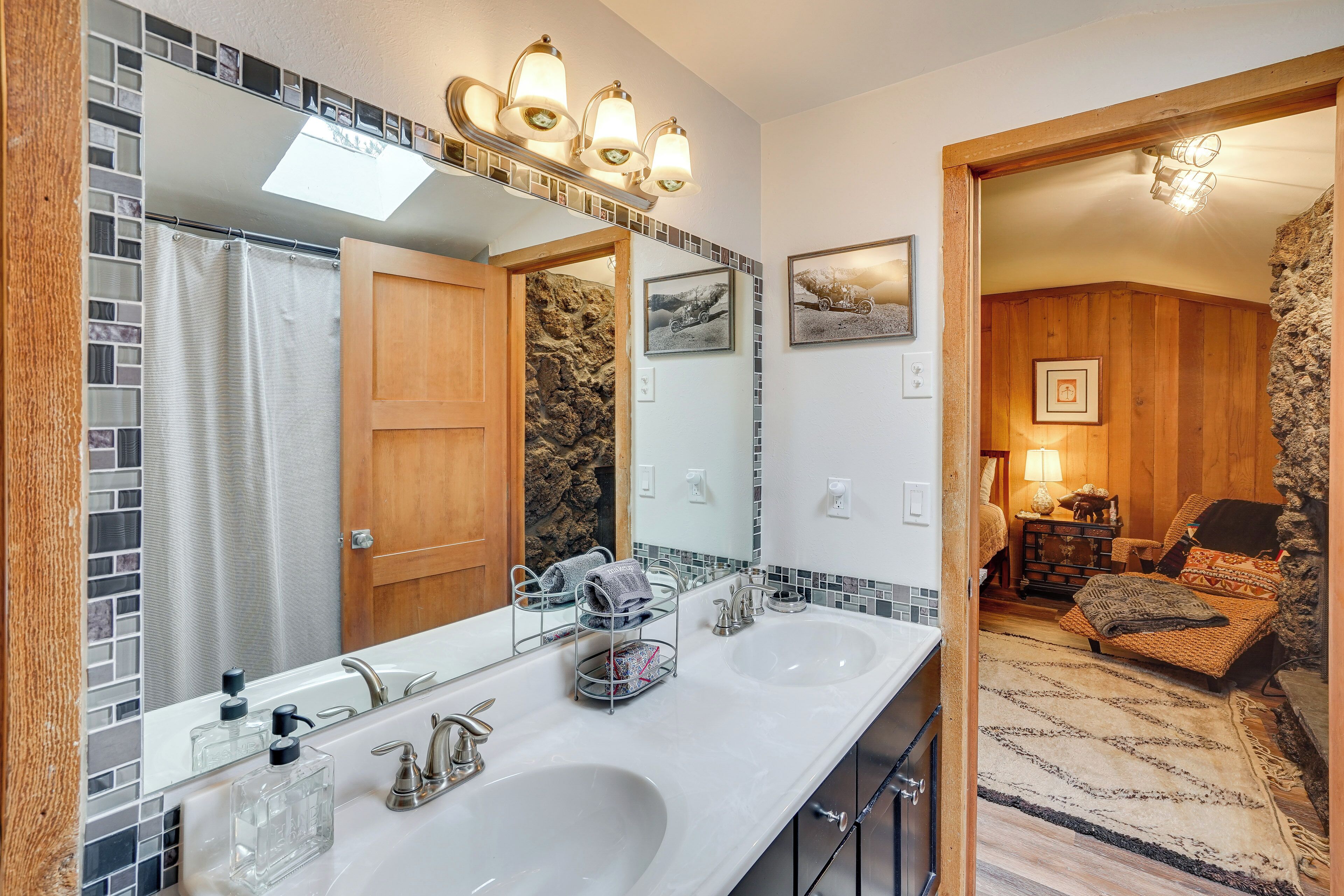 Une salle de bain avec deux lavabos, un grand miroir et un rideau de douche.