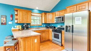 A kitchen with wooden cabinets, a stainless steel refrigerator, a microwave, and a stove. - Resort Amenities & Game Room: Arrowhead Lake Home! (Pocono Lake)