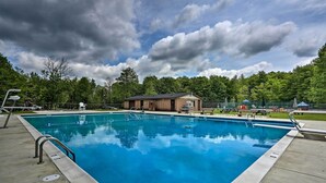 A rectangular swimming pool with a metal ladder on one side, surrounded by a concrete deck. - Resort Amenities & Game Room: Arrowhead Lake Home! (Pocono Lake)