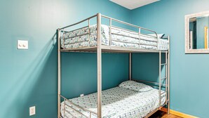 A bunk bed in a room with teal walls and a window. - Resort Amenities & Game Room: Arrowhead Lake Home! (Pocono Lake)