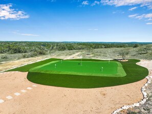 A golf course with a green fairway, sand bunkers, and a flagstick.