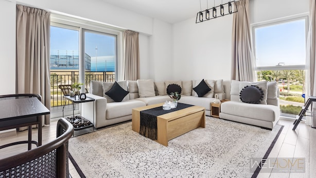Een moderne woonkamer met een bank, salontafel en een eethoek.