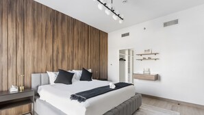 Een moderne slaapkamer met een groot bed, een nachtkastje, een kledingkast en een inbouwkast.