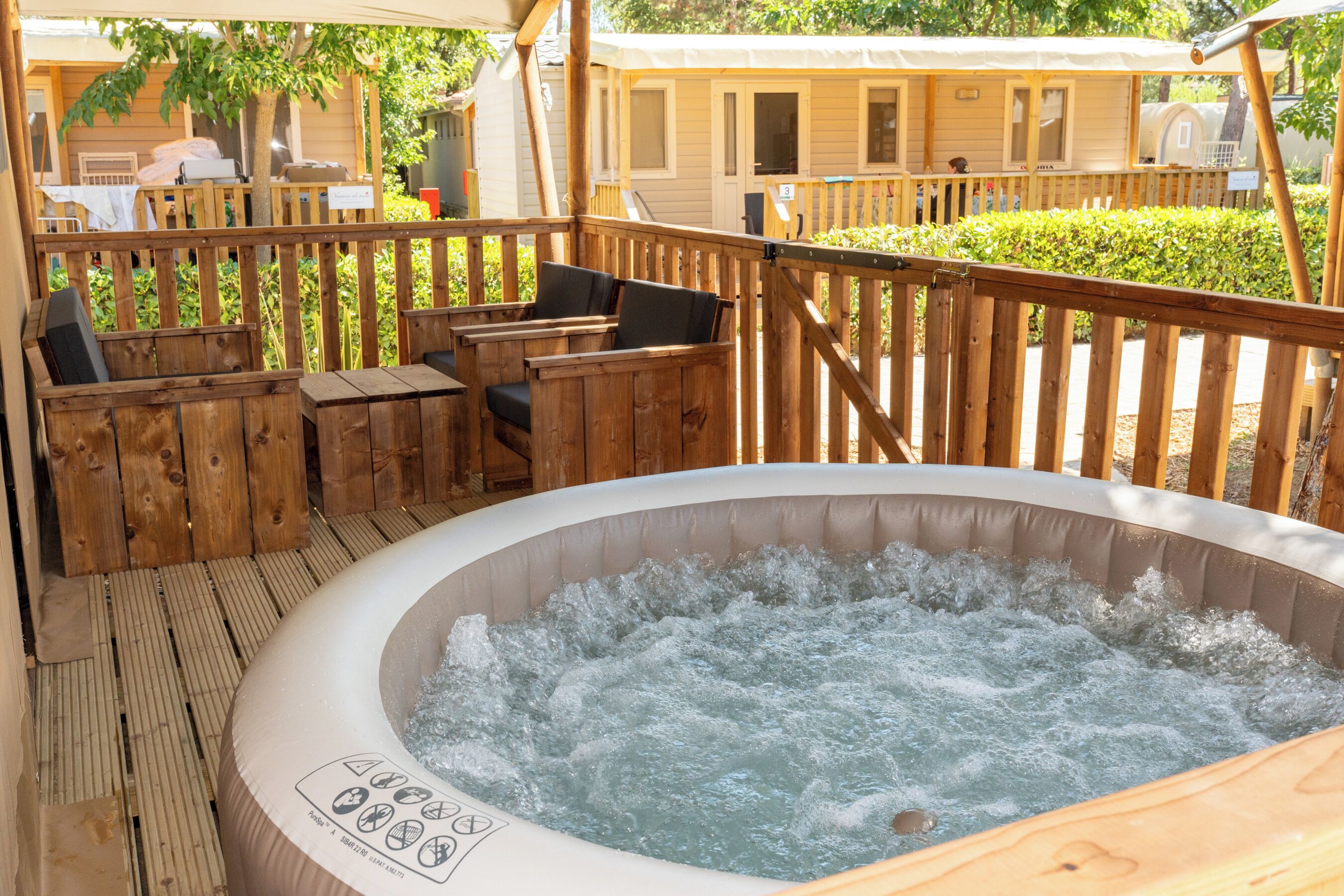 A hot tub with a wooden deck and outdoor seating area.