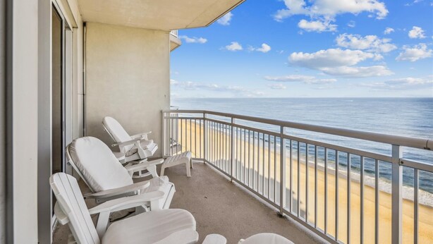 A balcony with white chairs and a view of the ocean. - Direct Oceanfront 3-bedroom 3 bath condo with direct beach access, fitness room, indoor and outdoor pool (Ocean City)
