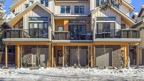 A multi-story building with a symmetrical facade, large windows, and balconies. - NEW Schloss by SSR Top View HOT TUB 5BR ( BL# RES-11684 ) (Canmore)